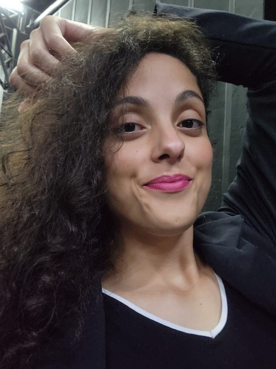 Amanda no camarim, com a mão no cabelo